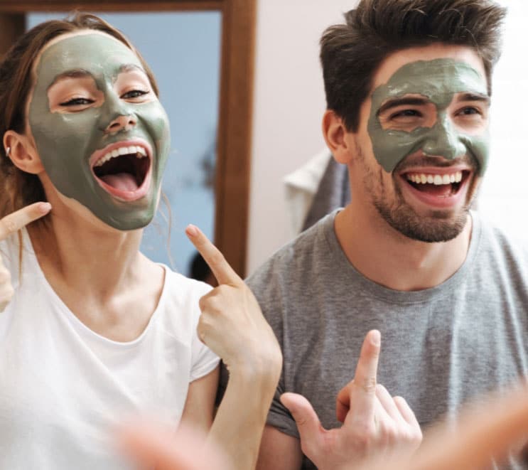 A man and woman in facial face masks smile widely, group med spa events