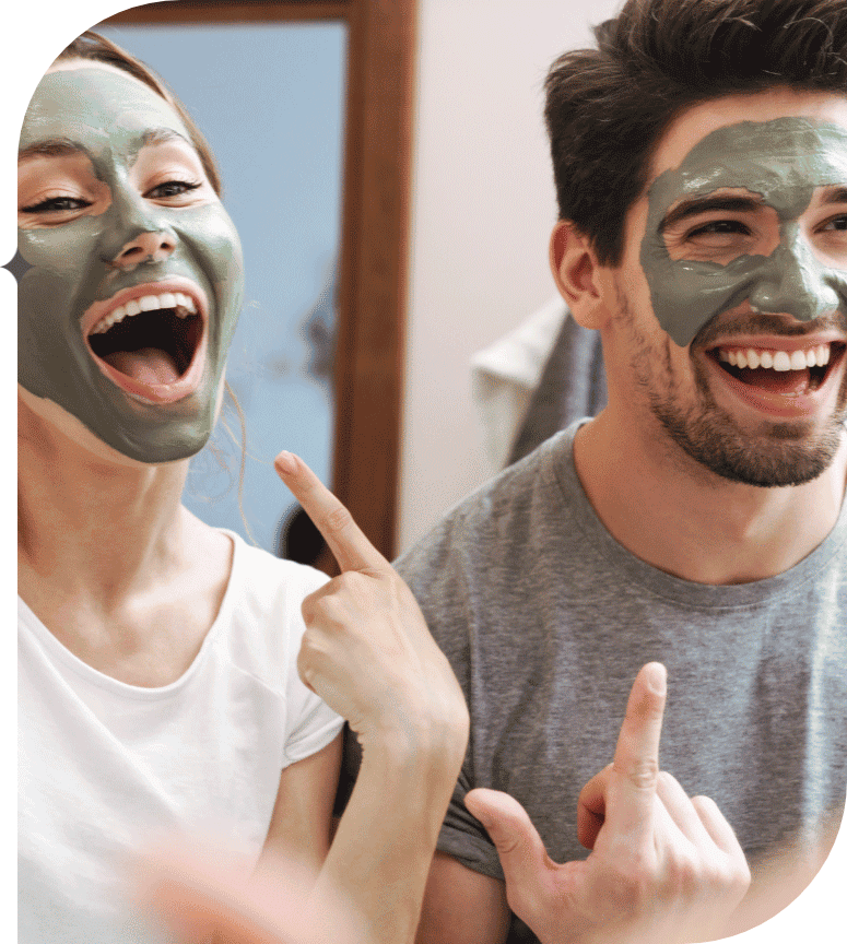 A woman and man happily show off their face masks