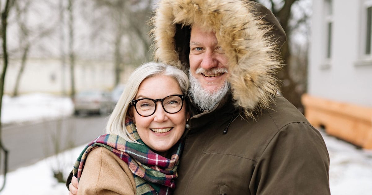 White haired couple stand together on sidewalk in winter jackets, Alzheimers in Women Linked to Hormone Imbalance