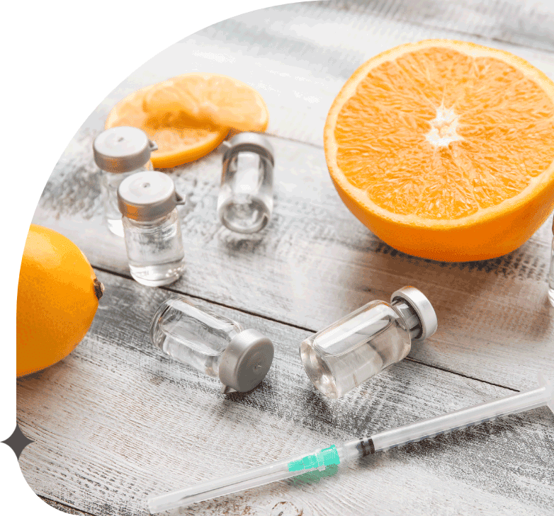 Ampules with vitamin C, syringe and citrus fruits on wooden background