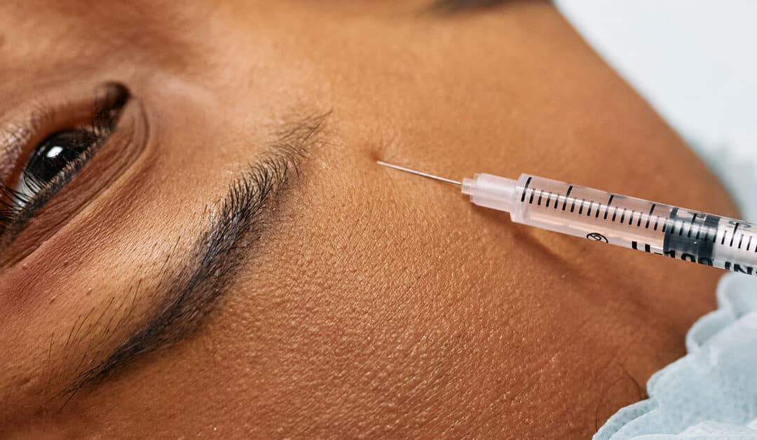 A woman's forehead gets injected with Botox